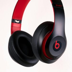 Close-up of stylish black and red wireless headphones on a white background.